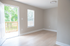 Bright, airy room with wood flooring and a private balcony view, perfect for a cozy living space.