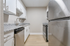 Modern galley kitchen with sleek stainless steel appliances, elegant granite countertops, and crisp white cabinetry.