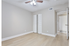 Bright and inviting room with elegant wood flooring, large louvered closet doors, and a modern ceiling fan, perfect for a cozy bedroom or stylish office space.