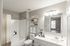 Elegant and modern bathroom with chic vanity and ample shelving, bathed in natural light, virtually staged.