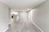 Bright open-concept living area with sleek laminate flooring and modern kitchen featuring stainless steel appliances.