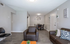 Inviting living room and dining area with modern decor, featuring comfortable brown seating, stylish wood flooring, and tasteful wall art.