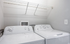 Convenient in-unit laundry room featuring modern washer and dryer with ample overhead shelving for storage.