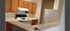 Modern kitchen with sleek countertops, wooden cabinetry, and a convenient bar area in a welcoming apartment setting.