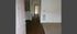 Inviting apartment entrance featuring a sleek wooden hallway leading to a brightly lit interior.