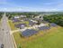 Expansive aerial view of a serene residential apartment complex surrounded by lush greenery and ample parking spaces, offering a tranquil suburban lifestyle.