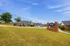 Charming Patterson Place Apartments with beautifully landscaped grounds, showcasing spacious brick buildings under a vibrant blue sky.