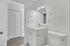 Sleek and modern bathroom with elegant white vanity, contemporary fixtures, and natural light enhancing the bright decor.