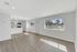 Bright and modern open-plan living area with sleek wood flooring, large windows, and a contemporary kitchen featuring stainless steel appliances.