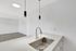 Modern kitchen with sleek countertops and elegant pendant lighting in a bright open-concept apartment.