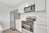 Modern kitchen with sleek stainless steel appliances, white cabinetry, and elegant countertops.