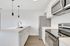 Modern kitchen featuring sleek stainless steel appliances, elegant white cabinetry, and stylish pendant lighting. Perfect for culinary enthusiasts seeking a chic and functional space.