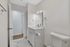 Modern bathroom featuring sleek white vanity, elegant marble flooring, and contemporary fixtures.