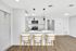 Modern kitchen with sleek white cabinets, stainless steel appliances, and an inviting breakfast bar with stylish seating.