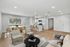 Modern open-concept living area with a stylish kitchen, elegant dining space, and cozy seating, featuring warm wood flooring and ample natural light.