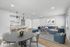 Modern open-concept living and dining area with sleek kitchen and cozy furnishings, perfect for stylish entertaining and relaxation.