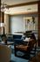 Luxurious modern living room featuring a stylish blue velvet sofa, elegant wooden furniture, and a sophisticated light fixture, creating a chic and inviting space.