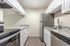 Modern kitchen with sleek white cabinetry, granite countertops, and stainless steel appliances for a stylish culinary experience.