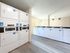 Bright and spacious laundry room with modern washing and drying machines on sleek wooden flooring.