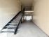 Bright and welcoming apartment corridor with sleek metal staircase and modern design.