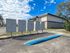 Charming apartment building with modern mailboxes beneath a vibrant blue sky, set by a well-maintained pathway.