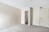 Spacious bedroom with plush carpet, neutral tones, and an ensuite bathroom for modern comfort.