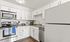 Chic modern kitchen with sleek white cabinetry, stainless steel appliances, and elegant granite countertops.
