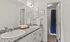 Elegant bathroom with dual sinks, granite countertops, and chic wall art, creating a spa-like ambiance.