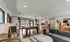 Chic and spacious open-concept living area featuring a stylish pool table, modern kitchen with bar seating, and a cozy lounge area with vibrant d&eacute;cor.