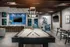 Clubroom with pool table, wall mounted tv and chairs.