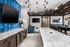 Club room bar area with large granite table, mounted tv with blue tile backsplash
