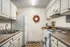 Kitchen with tan laminate countertops, stove, breakfast bar, sink, refrigerator and beige cabinets