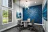 Work room with glass exterior, meeting table that seats next to window. four. Glass modern light fixture hanging from ceiling above the table