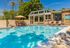 Rectangular community pool with lounge chairs and leasing office in background.