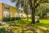 Community green space in front of apartment homes. There is a large oak tree and lots of grass surrounding the building.