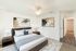 Bedroom with carpet and hardwood floors, wooden furniture set, and a white ceiling fan.