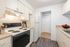 Kitchen with hardwood floors, beige cabinets, and white appliances.