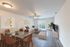 Living and Dining area with hardwood floors, beige walls, glass table, leather chairs, and a white couch.
