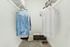 Carpeted walk in closet with hanging shirts, shoes on the ground as well as storage cubes.