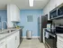 Galley kitchen with white cabinets and stainless steel appliances.