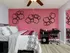 Bedroom with ceiling fan and furniture with red accent wall.