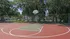 Half basket ball court enclosed in fence.