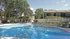 Beautiful community pool reflecting the trees, landscaping and buildings in the background.