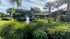 Lush landscaping with pond and fountain, and leasing office in background.
