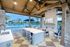 Outdoor lounge with kitchen appliances, televisions and firepit.