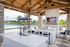 Outdoor lounge with kitchen appliances, televisions and firepit.