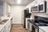 Kitchen with sink on the right and appliances on left.
