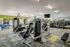 Fitness center with punching bag, cardio, and strength equipment. Two TVs are mounted on the wall.