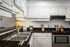 Kitchen with black granite countertop, white classic cabinets, and stainless steel oven