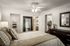 Bedroom with large queen bed, closet, full mirror and dresser.